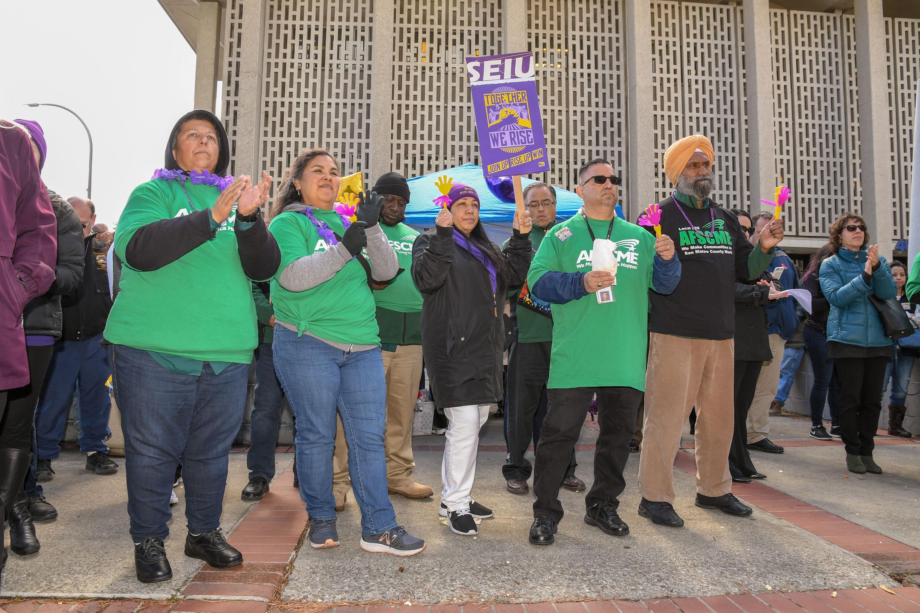AFSCME Local 829 members and SEIU members listen to speakers at the Together We Rise rally in San Mateo County.
